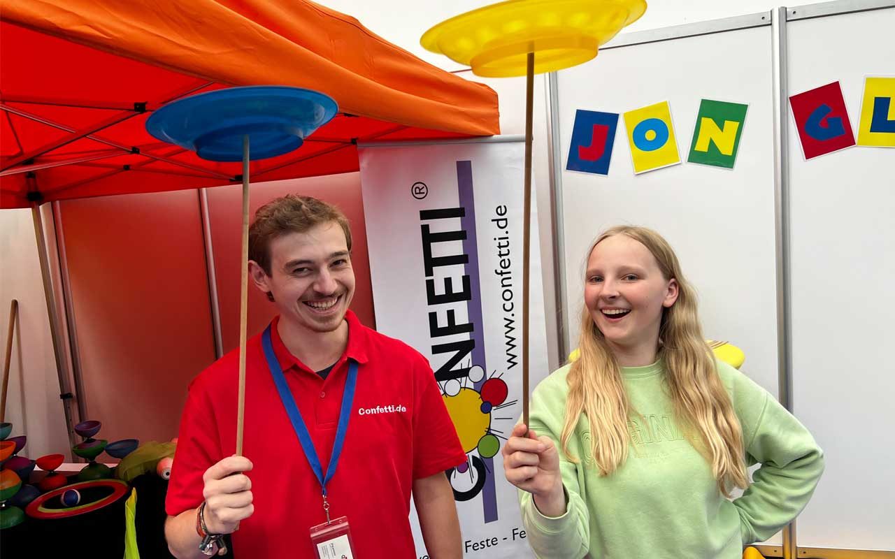 Im mobilen Jonglierstudio von Confetti.de auf der SPIEL Essen 2025 lernen Kinder und Erwachsene gemeinsam das Jonglieren mit Tellern, Bällen und Tüchern. Unter Anleitung erfahrener Spielpädagogen wird Lachen, Bewegung und Geschick miteinander verbunden. Ein Mitmach-Highlight in der Galeria, das generationsübergreifend begeistert.