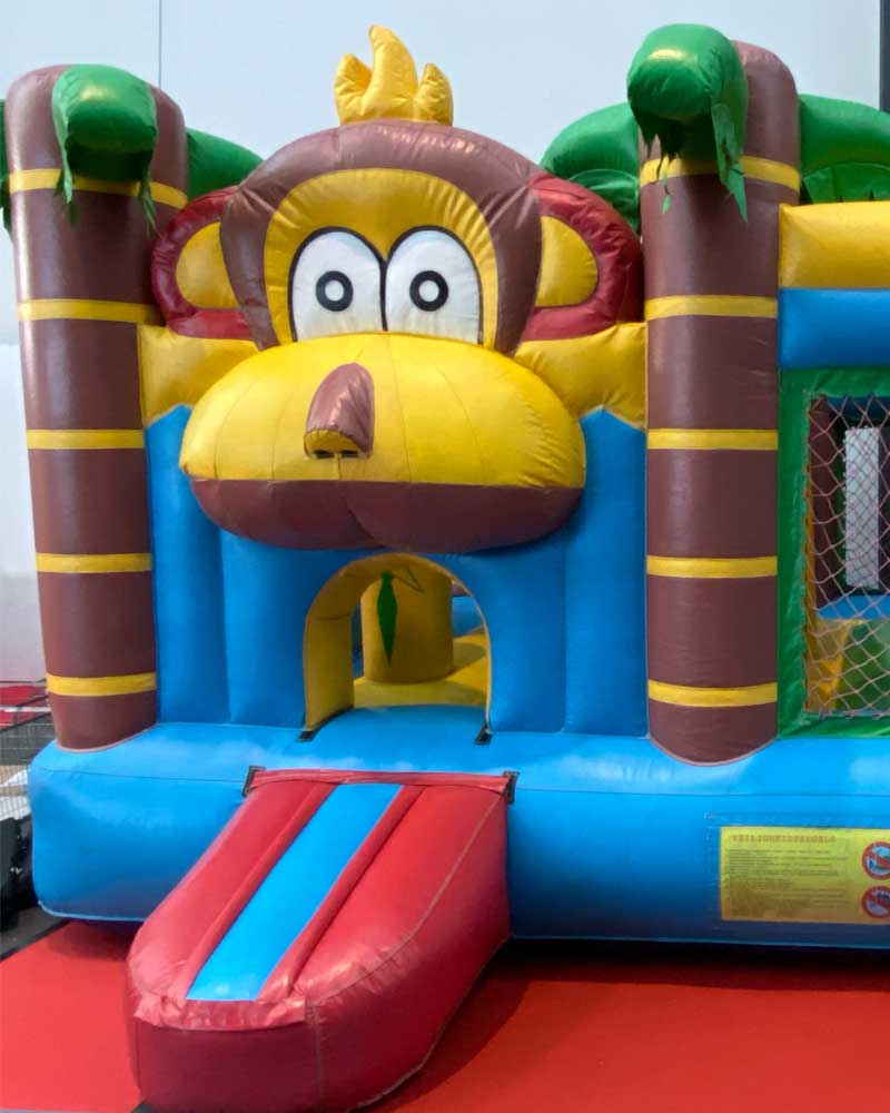 Bunte Multiplay-Hüpfburg von Konfetti.de auf der SPIEL Essen Kinderprogramm 2025 mit Rutsche und lustigem Tiermotiv